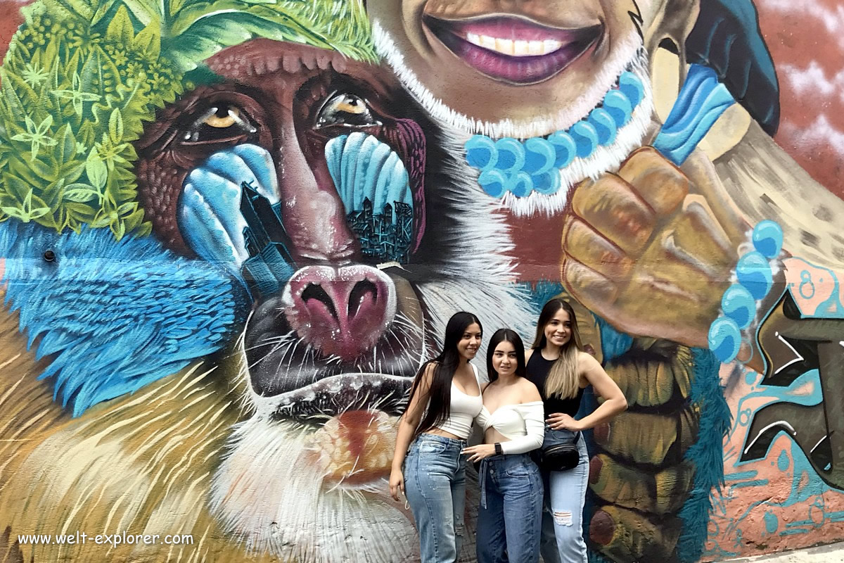 Kolumbianerin vor Graffiti in Medellin