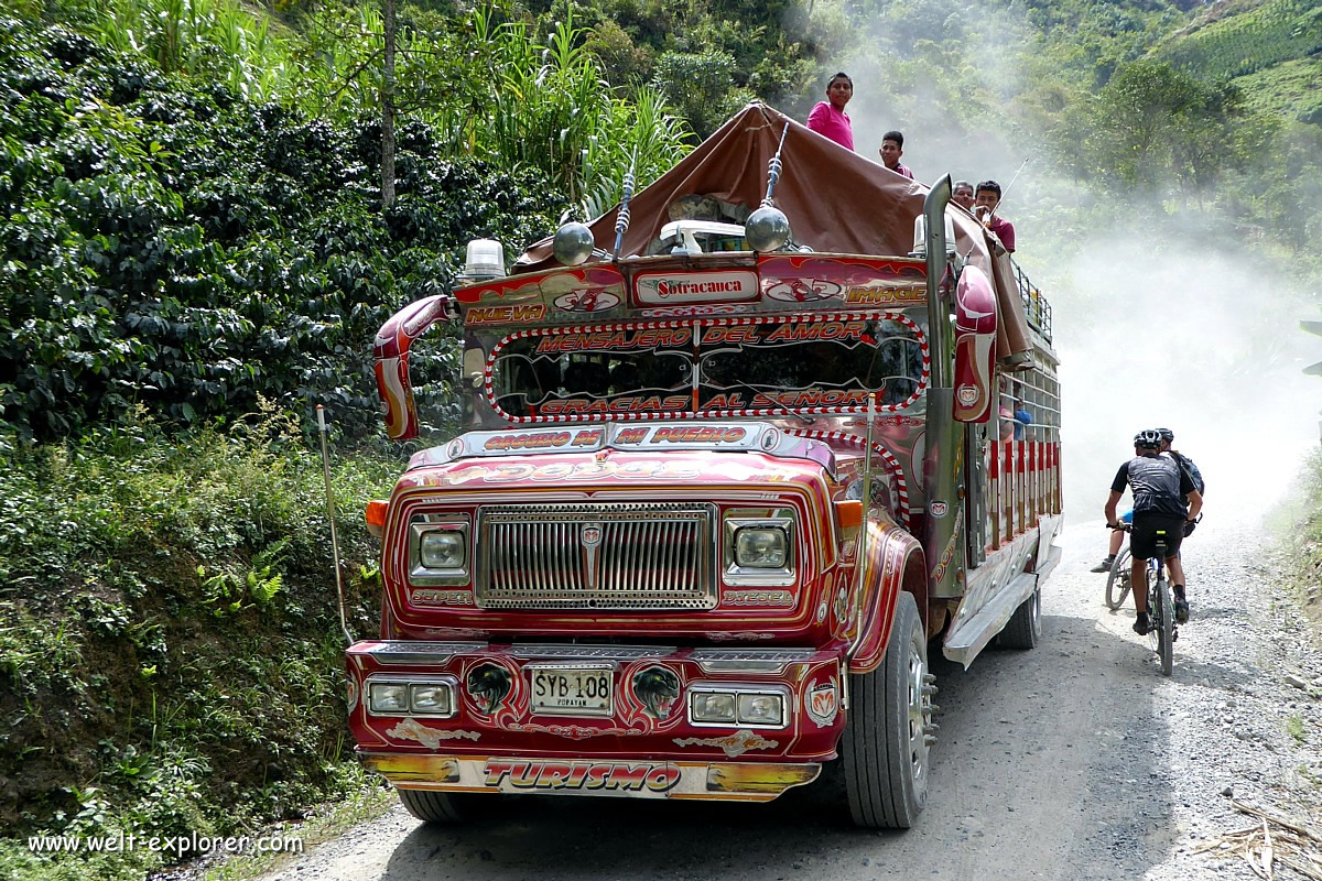 Kolumbianischer Bus Chiva mit Radfahrer