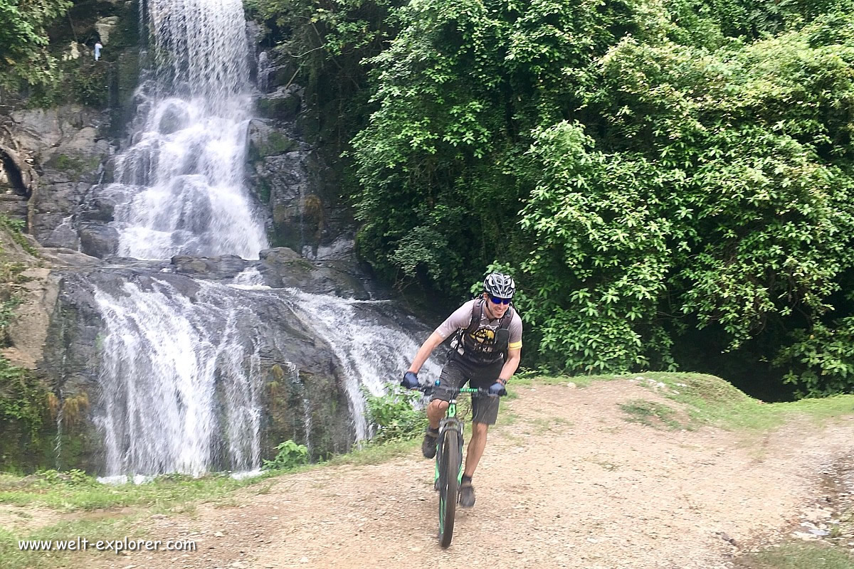 Mountainbiker vor Wasserfall